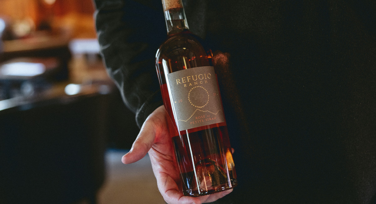 holding rose bottle